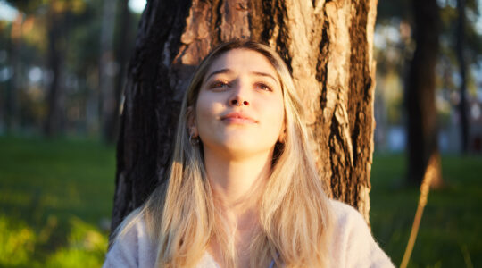 young girl dreaming while resting under the tree