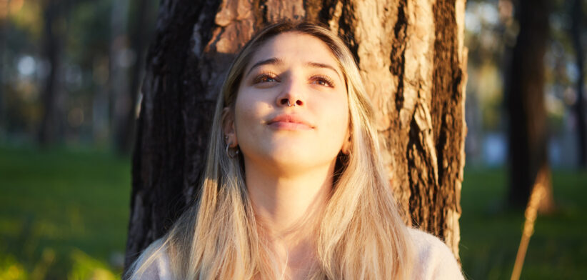 young girl dreaming while resting under the tree