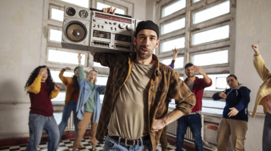 Man with boombox leads group dance session.