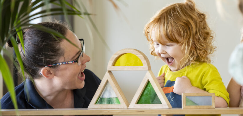 Educator_toddler_stacking_blocks_happy