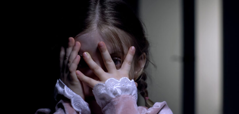Frightened little girl closing face with palms, afraid of ghosts phobia concept