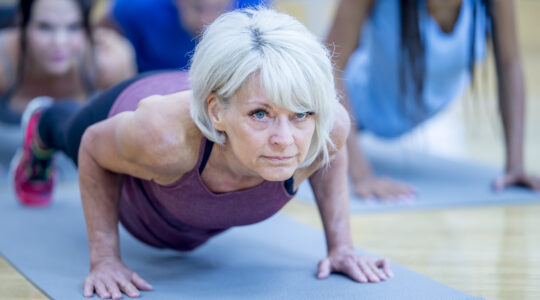 Senior Woman in Fitness Class in a Plank Pose stock photo