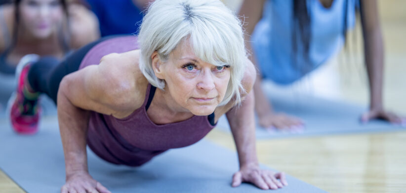 Senior Woman in Fitness Class in a Plank Pose stock photo