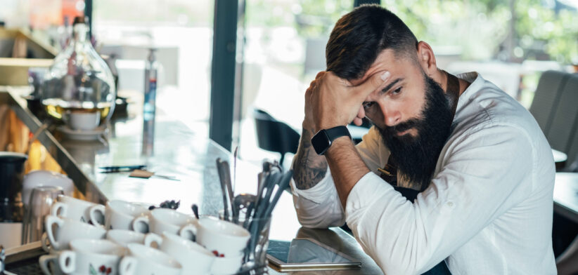 Worried Barista Using Digital Tablet in a Cafe
