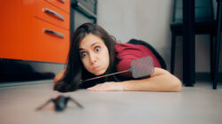 Woman Following a Big Insect on the Kitchen Floor