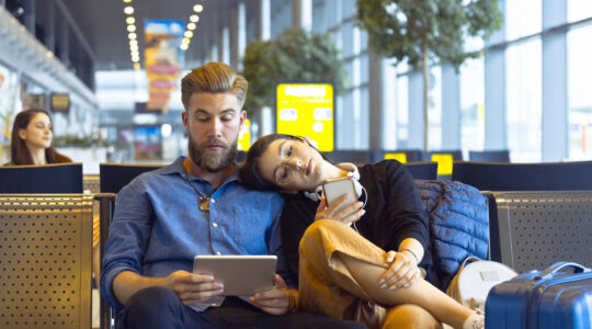 Young couple waiting for flight in airport area