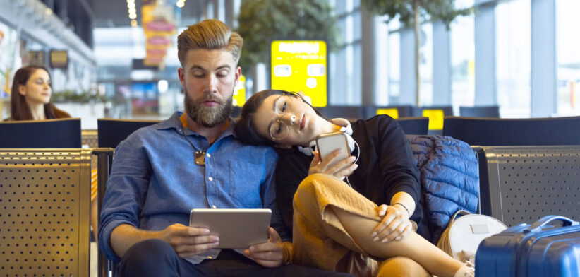Young couple waiting for flight in airport area