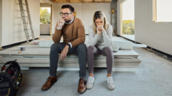 Worried couple having problems inside of their house under construction.