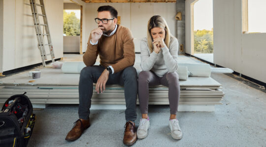 Worried couple having problems inside of their house under construction.