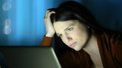 Worried woman in the night checks laptop