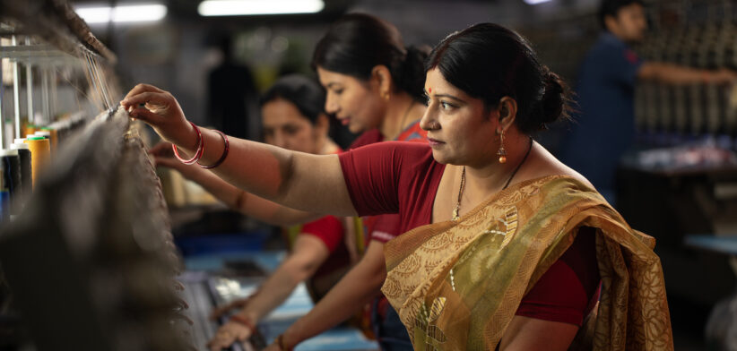 female coworkers operating equipment in textile factory