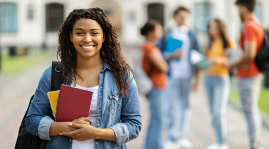 Loans for education concept. Portrait of happy black female student posing outdoors