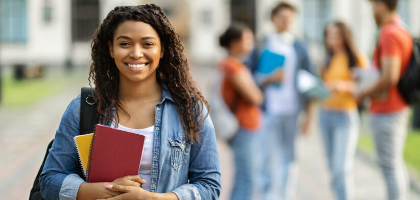 Loans for education concept. Portrait of happy black female student posing outdoors
