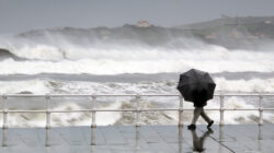 person protecting with umbrella in a rainy and windy day
