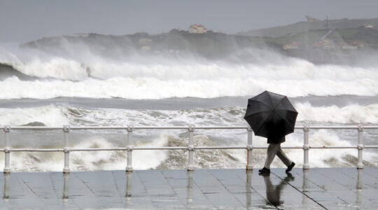person protecting with umbrella in a rainy and windy day