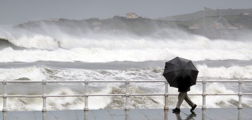 person protecting with umbrella in a rainy and windy day
