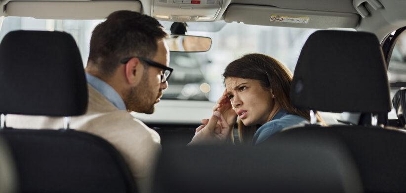 Young couple arguing inside of a car.