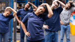 Group of warehouse employees stretching while taking a break from work