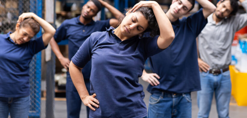 Group of warehouse employees stretching while taking a break from work
