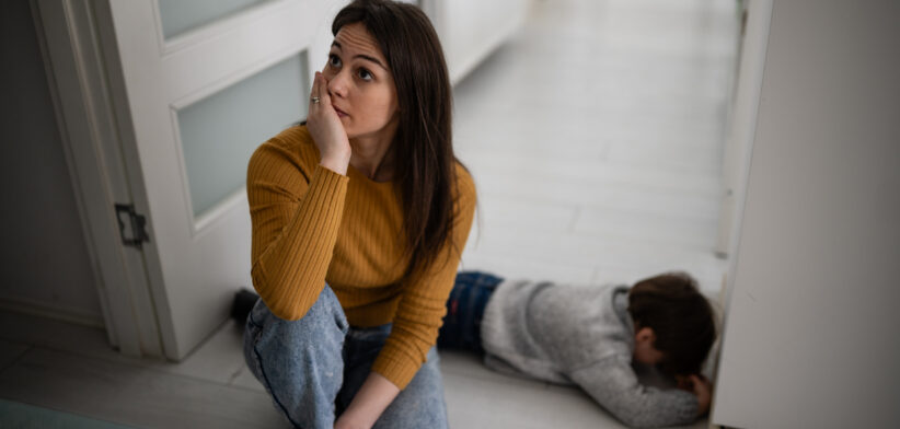 Stressed mother experiencing parenting burnout with child having tantrum