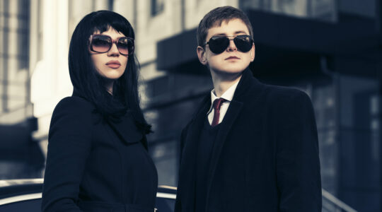 Young fashion business couple against office building