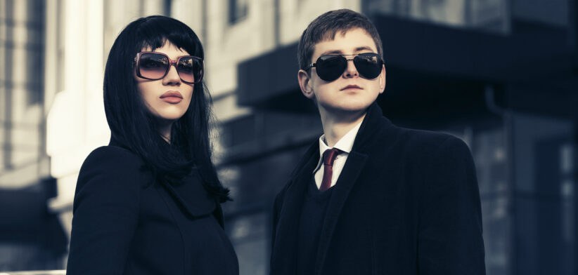 Young fashion business couple against office building