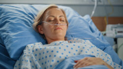 Hospital Ward: Portrait of Beautiful Young Woman Sleeping in Bed, Fully Recovering after Sickness. Female Patient Dreaming About Her Happy Healthy Future.