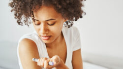 Female diabetic injecting insulin into her upper arm