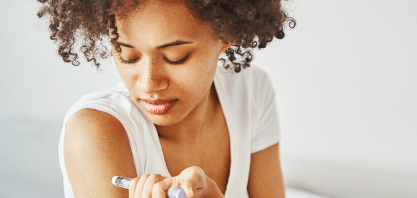 Female diabetic injecting insulin into her upper arm