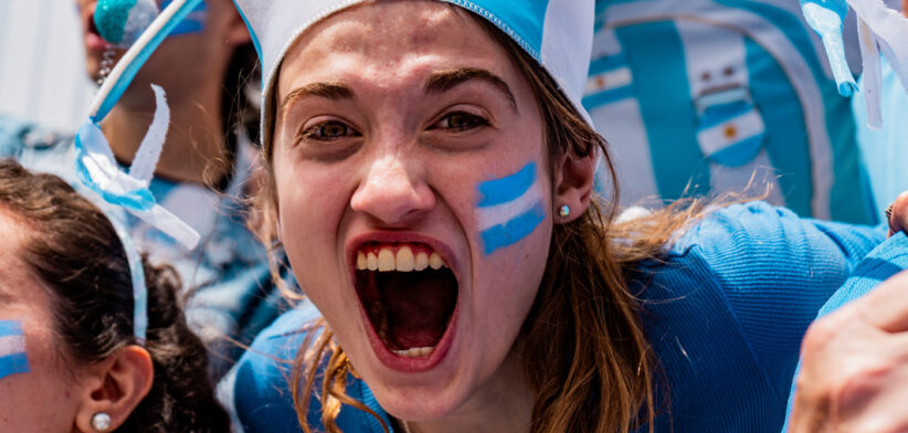 Portrait of a passionate female fan celebrating during an Argentine football match in the stands