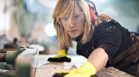 Blonde woman cutting a plank