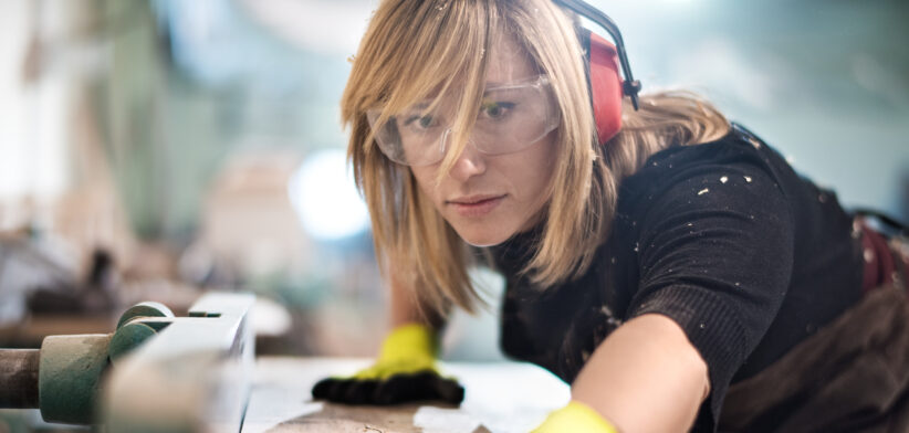 Blonde woman cutting a plank