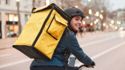 A Delivery biker looking over their shoulder.