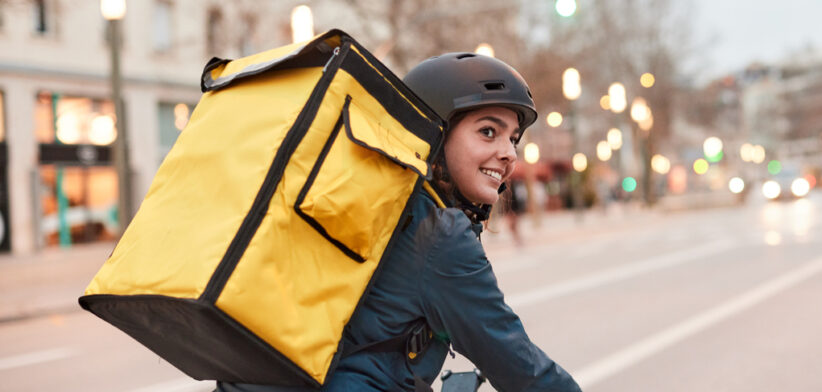 A Delivery biker looking over their shoulder.