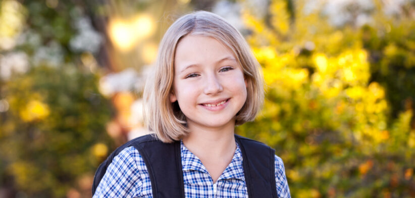 School girl walking home from school with backpack