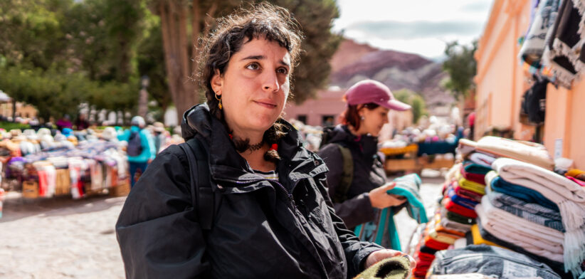 Mid adult tourist looking at souvenirs on a street market in historic district of Purmamarca, Argentina