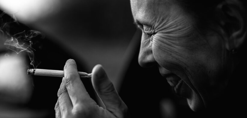 Black And White Close Portrait Of Woman Smoking Cigarette With Emotion