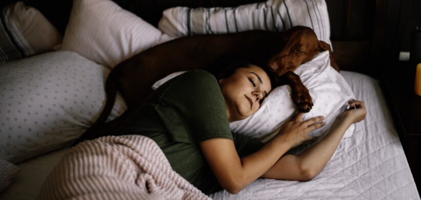 Girl sleeping with her dog.