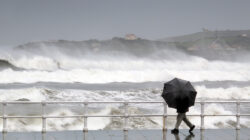 person protecting with umbrella in a rainy and windy day