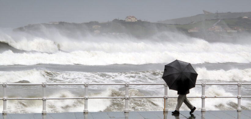 person protecting with umbrella in a rainy and windy day