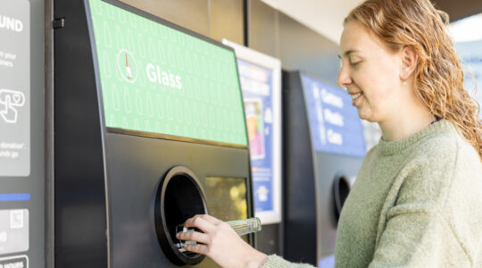 Young woman using a bottle recycling machine