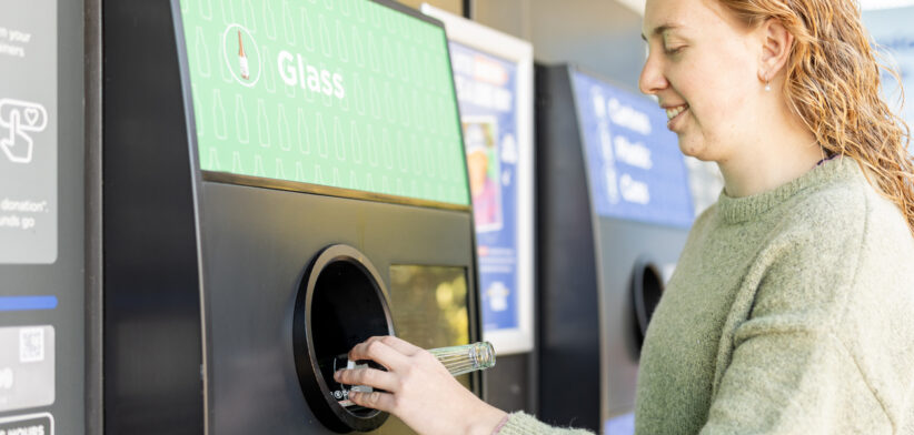 Young woman using a bottle recycling machine