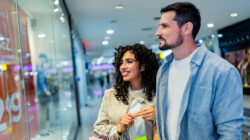 Couple walking through shopping mall with shopping bags