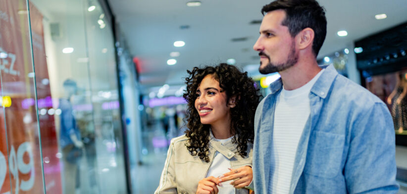 Couple walking through shopping mall with shopping bags