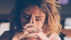 Tired Young Woman Leaning Head on Hands