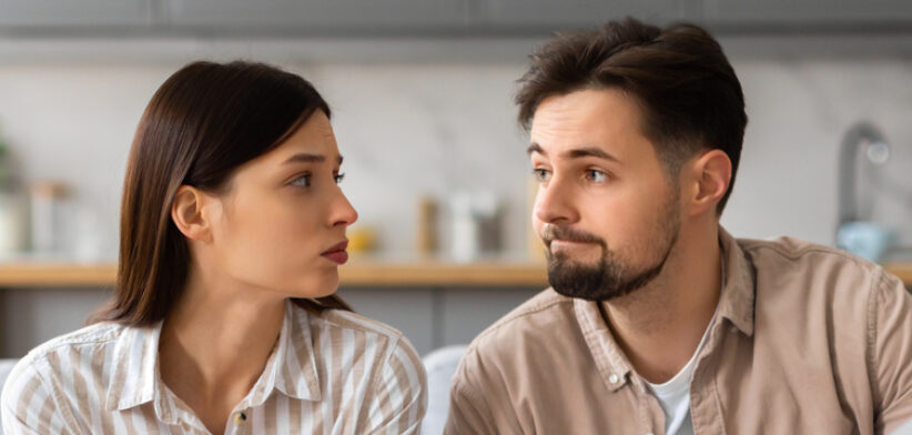 Worried couple reviewing documents with laptop
