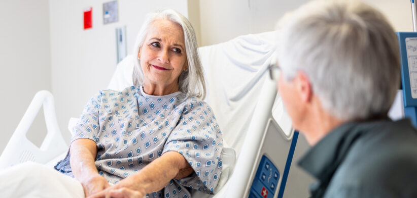 Senior woman in hospital bed with her husband