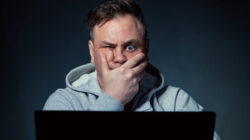 Stressed man sitting in front of laptop