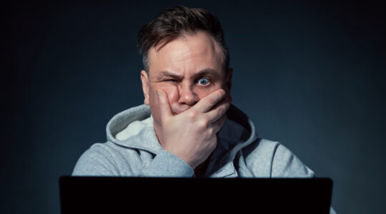 Stressed man sitting in front of laptop