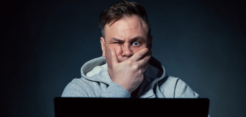 Stressed man sitting in front of laptop